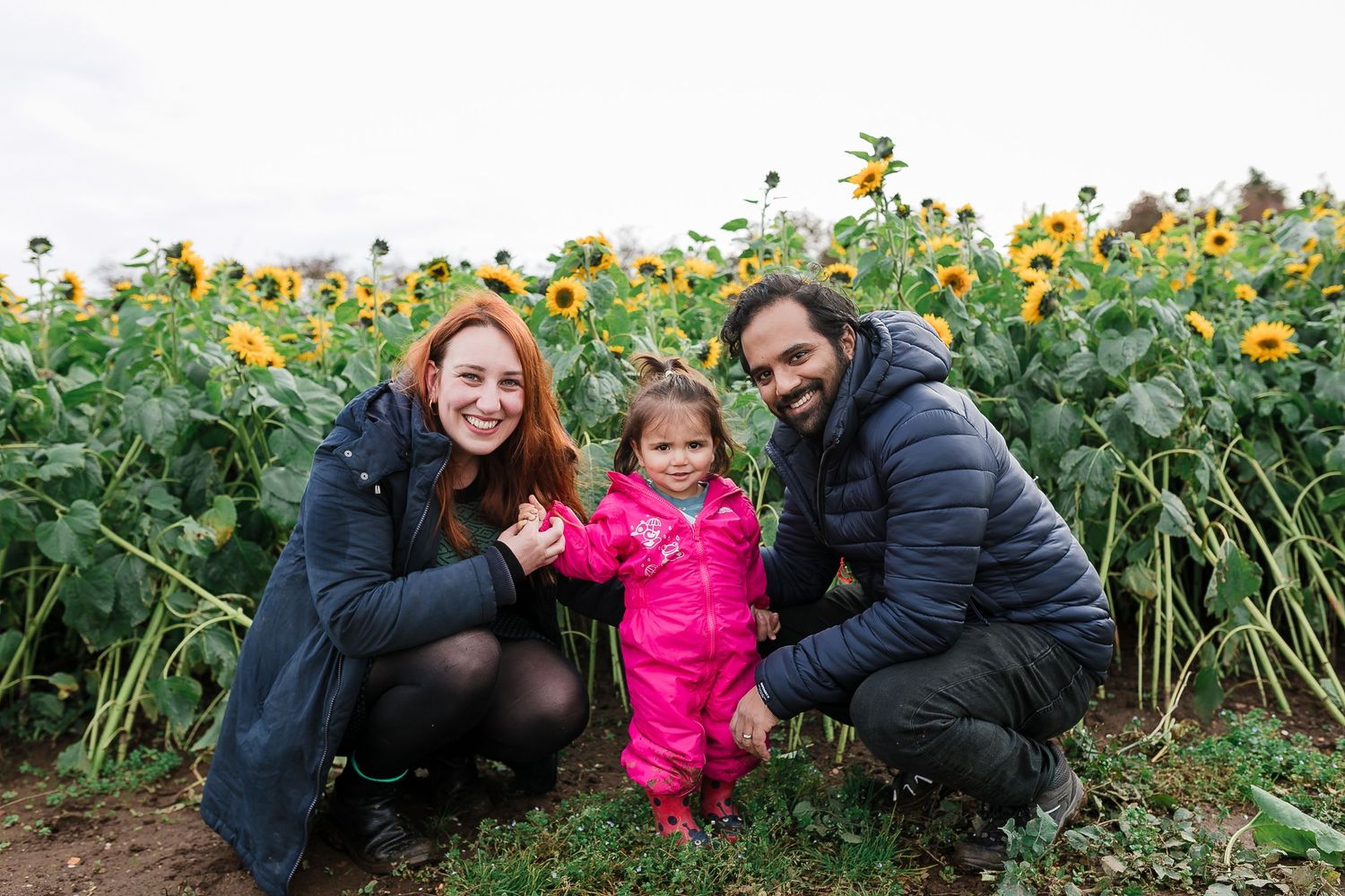 Family poses together by sunflower field during autumn pumpkin patch visit. Photographer. Hull. East Yorkshire. Photography