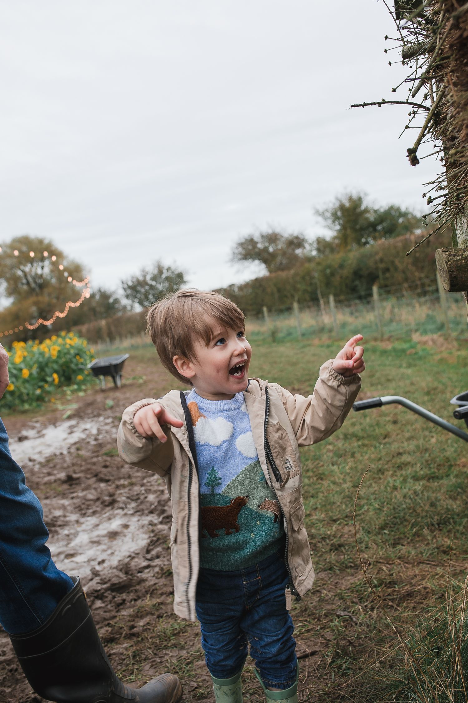 Child in beige jacket explores muddy path near sunflower field. Photographer. Hull. East Yorkshire. Photography