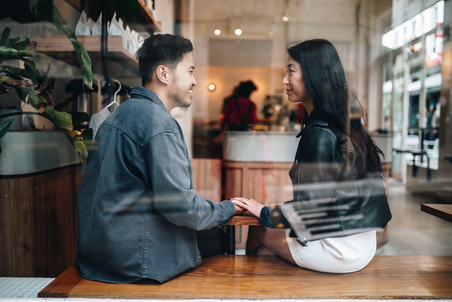 Couple having intimate conversation at cafe table by window taken by Melbourne casual couples and engagement photographer
