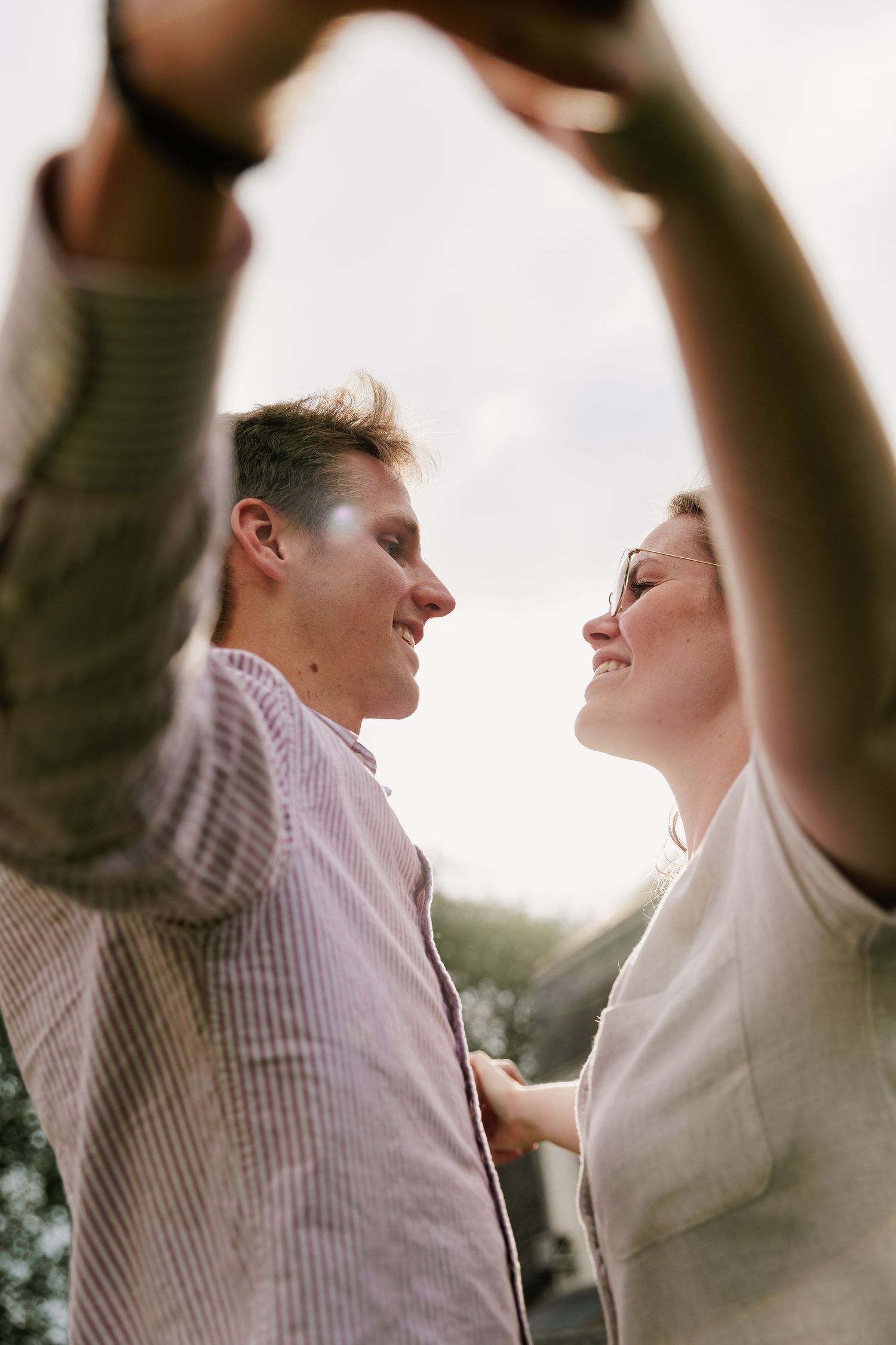 Intimate couples portrait captured in soft natural lighting with joyful expressions.