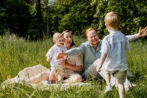 Candid moments of family interaction during a sunny outdoor photoshoot.