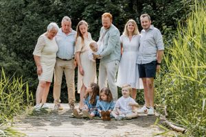Large family group gathered outdoors for a casual photo session in natural setting.
