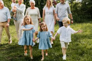 Extended family in coordinated blue and white outfits posing together outdoors.