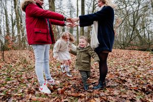 Playful moments captured in a wooded area covered with red and brown fallen leaves.