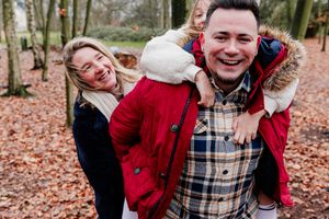 Candid laughter and embraces during an autumn family photoshoot in the woods.