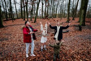 Autumn wedding celebration in forest with fallen leaves covering the ground.