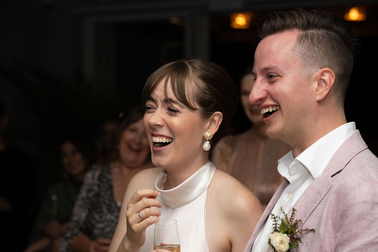 A couple shares a candid moment of laughter during their wedding celebration.