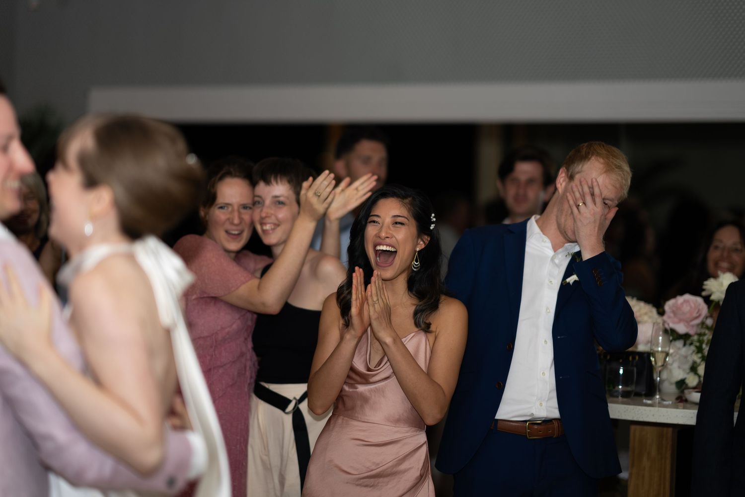 Wedding guests celebrating and dancing joyfully at a reception.
