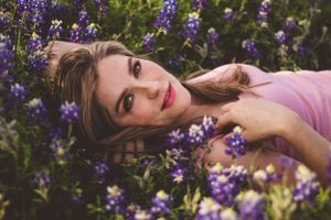 A dreamy outdoor portrait among texas bluebonnets with soft natural lighting and a pink shirt. Bluebonnet Mini session Austin Texas