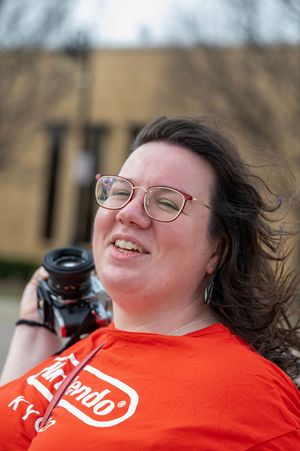 A person wearing glasses and an orange t-shirt smiles while holding a camera in a series of candid outdoor shots.