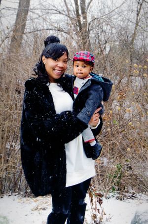 Winter scene with parent and child in warm clothing during snowfall.