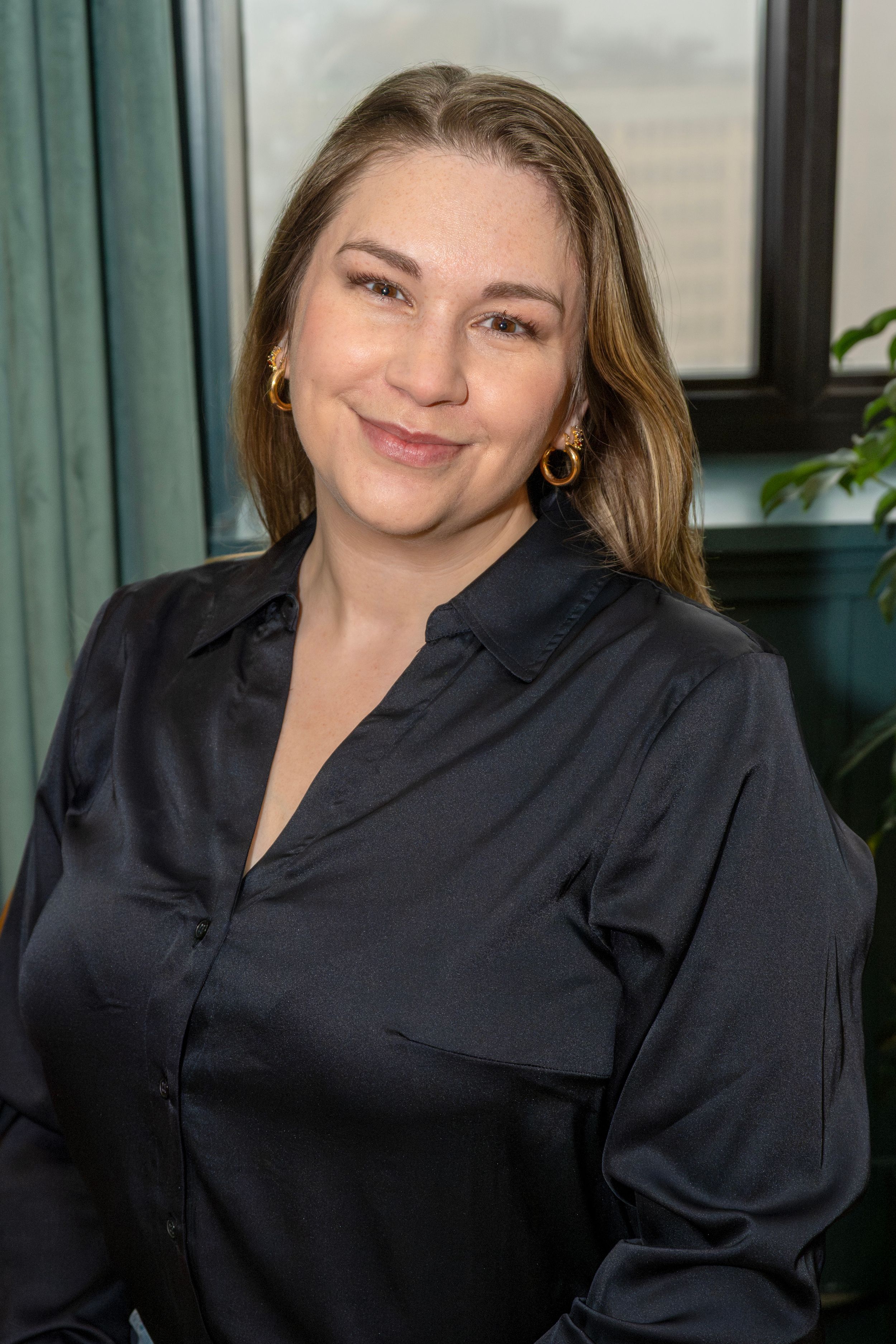 A sequence of photos showing a person in a black silk blouse smiling and posing against a green curtain background.