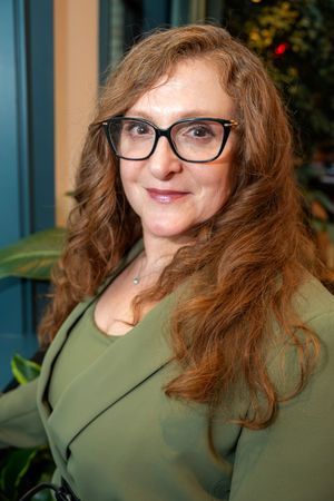 A series of five similar photos showing someone in glasses and a green top smiling against a blurred background.