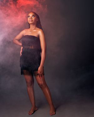 lady wearing a black cocktail dress with red smoke
