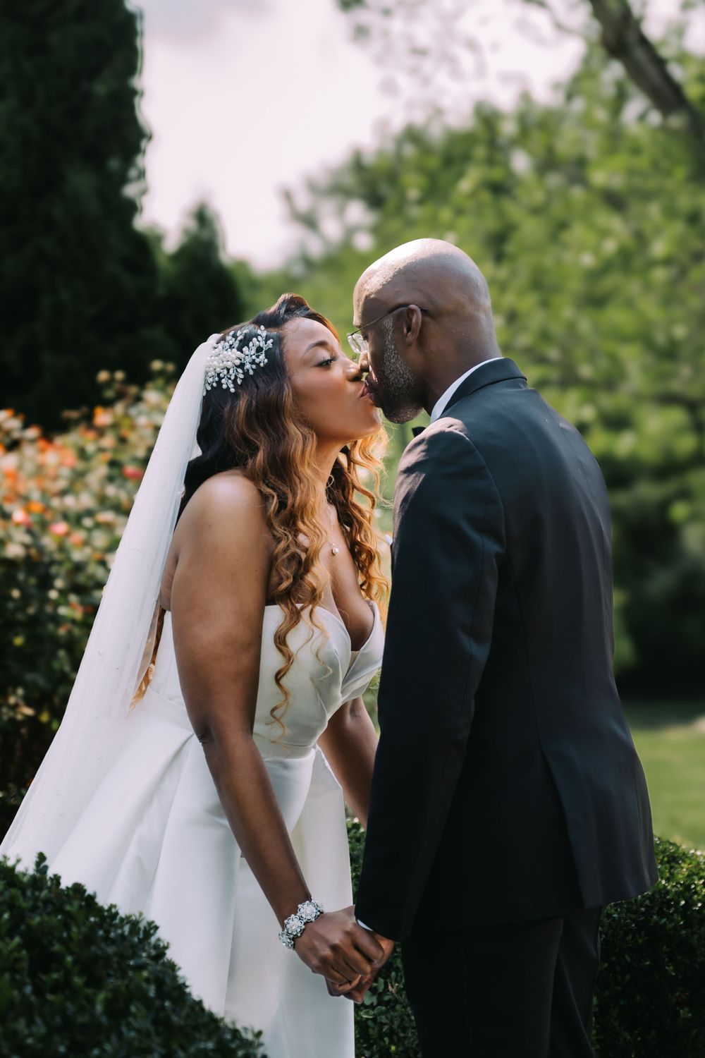 A romantic outdoor garden wedding scene with blooming orange flowers in the background.