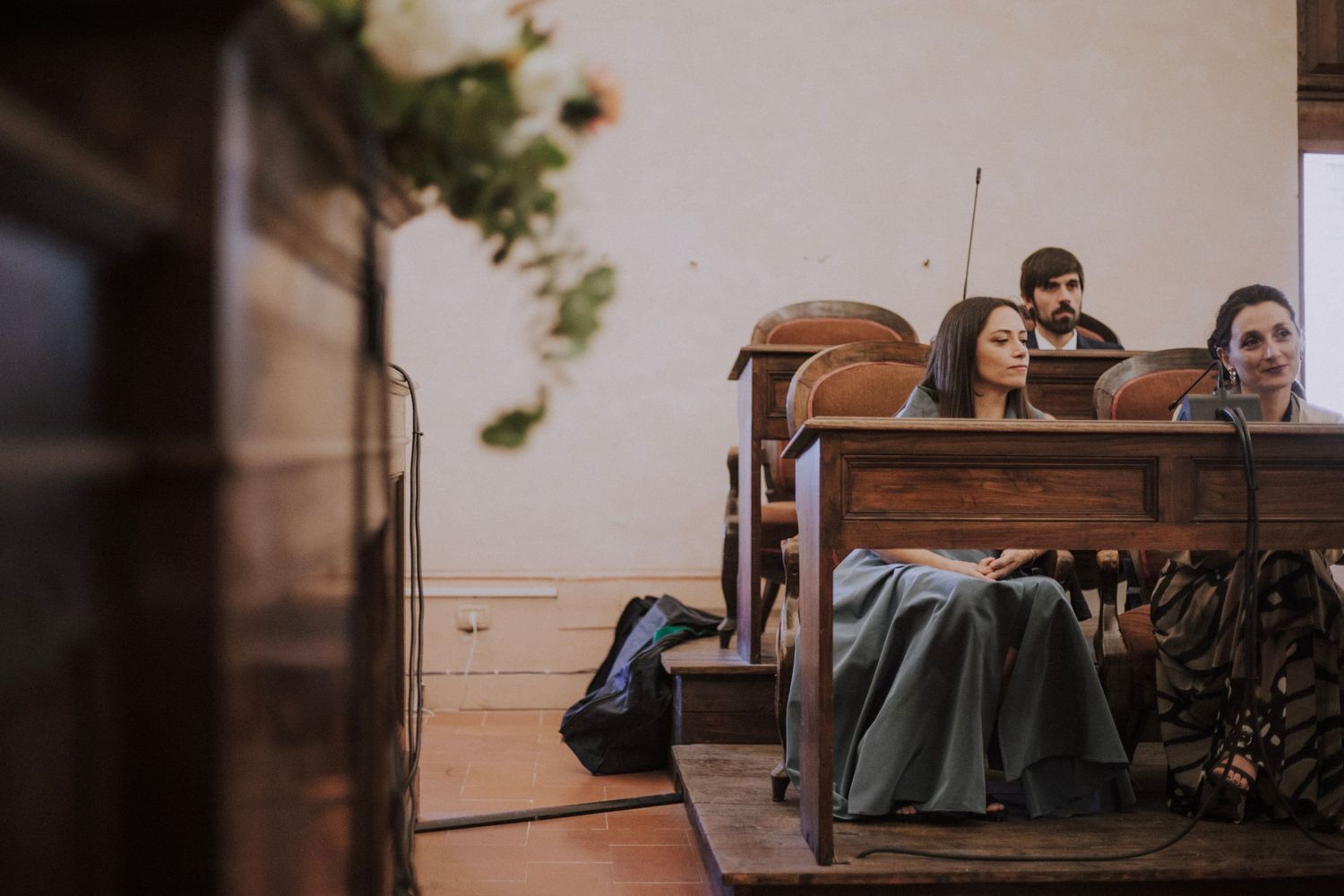 A joyful moment captured during a wedding ceremony with attendees seated in wooden pews.