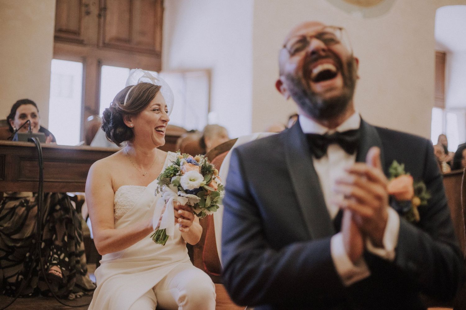 A civil wedding ceremony taking place in an elegant room with official flags and floral arrangements.