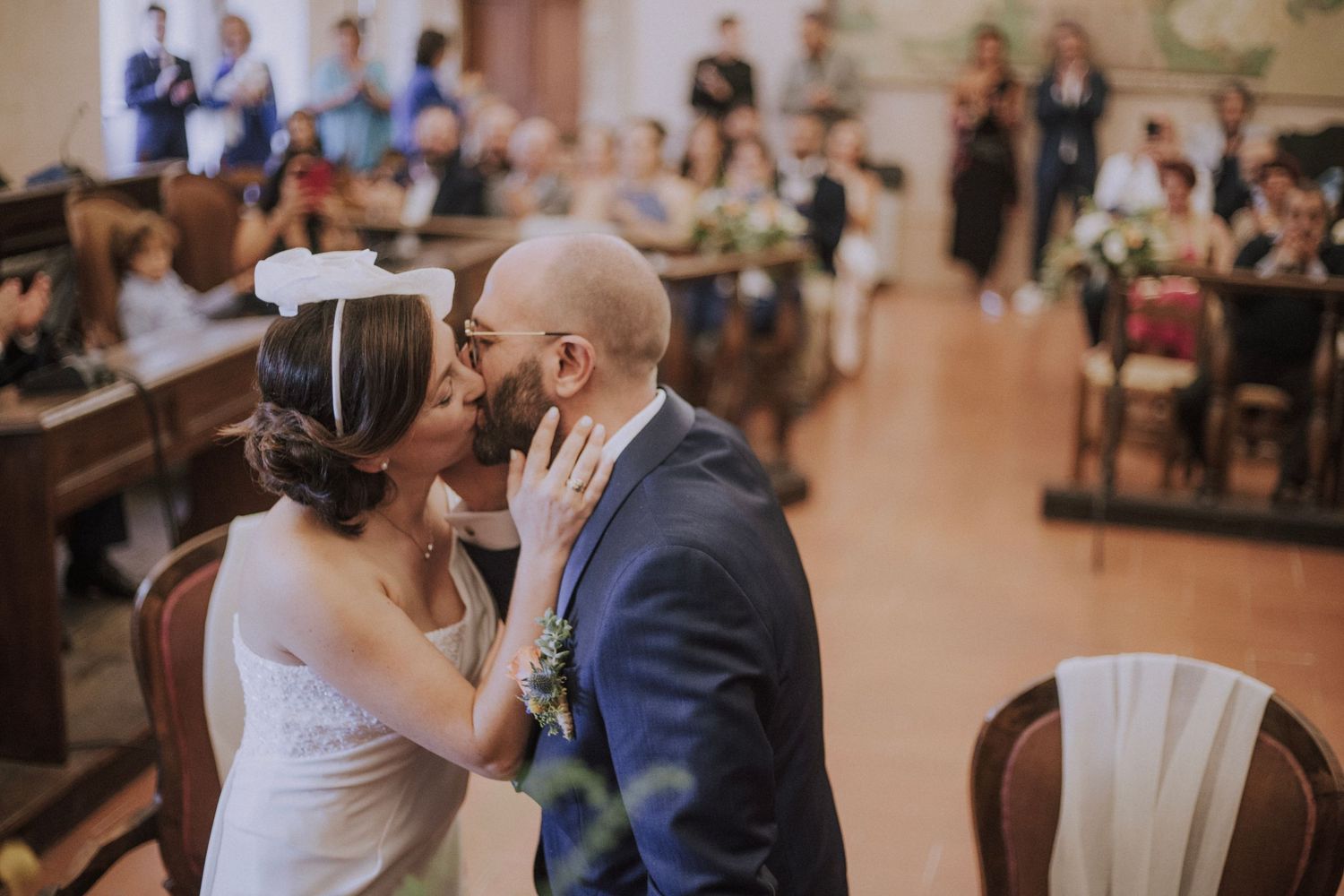 A dramatic black and white wedding photo captured in a corridor with natural lighting.