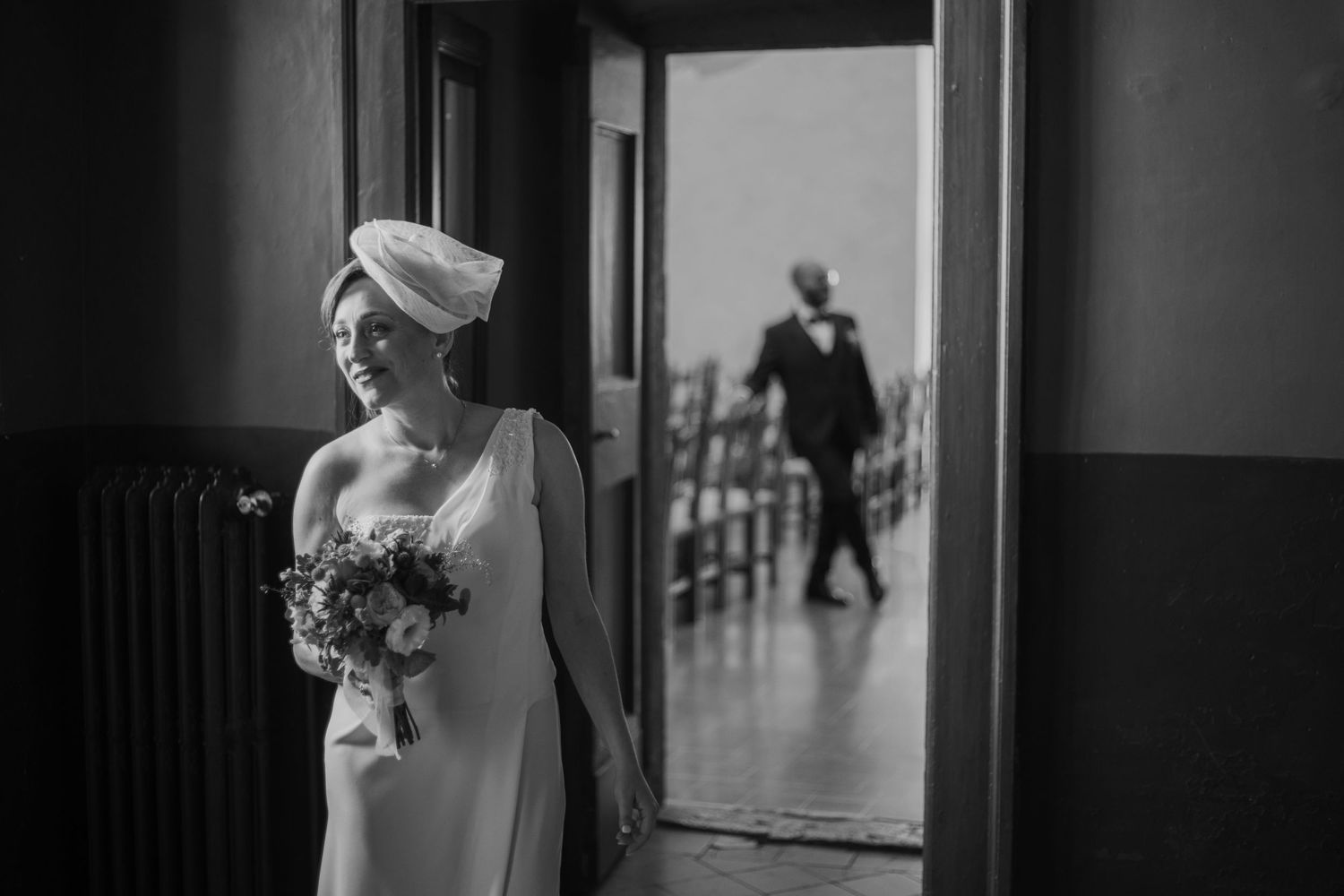 A couple poses on stone steps under an ancient archway during their wedding photoshoot.