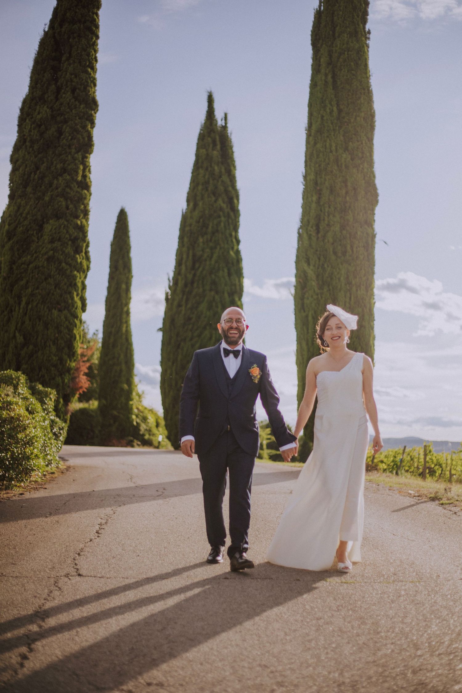 A romantic stroll along a cypress-lined path in an Italian countryside setting.