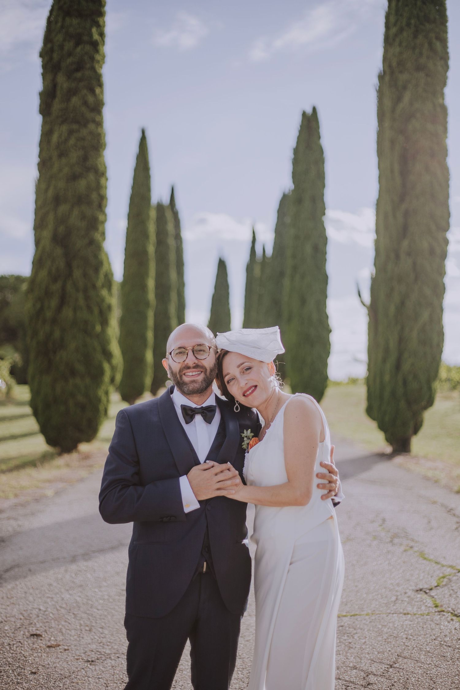 An intimate wedding portrait framed by majestic Italian cypress trees.