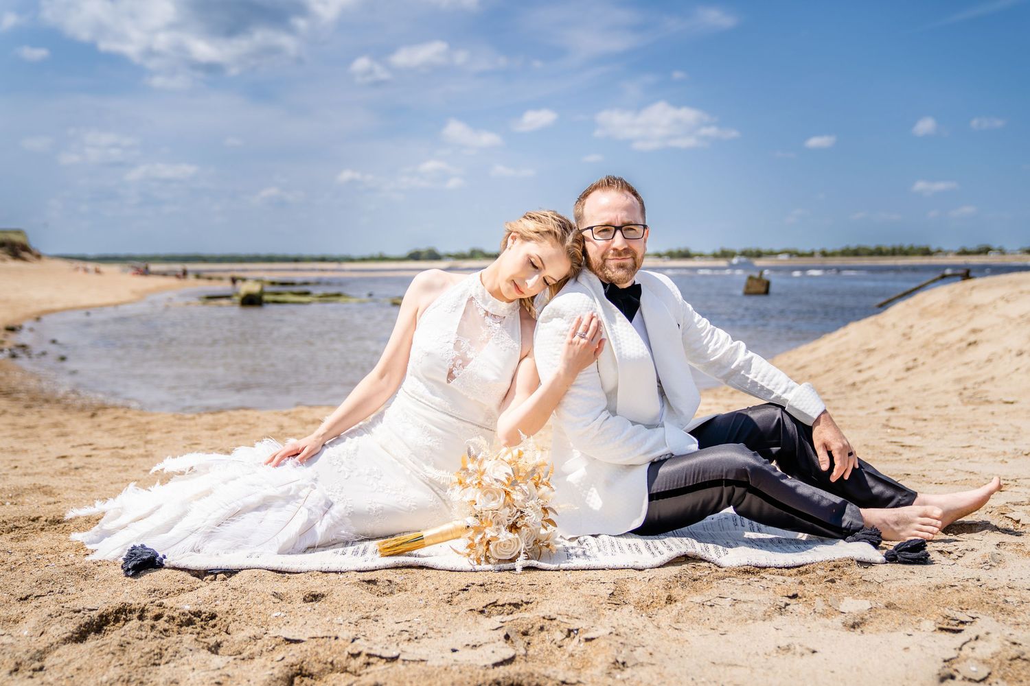 Couple in wedding attire on a beach in Gloucester, Massachusetts during their wedding portraits.