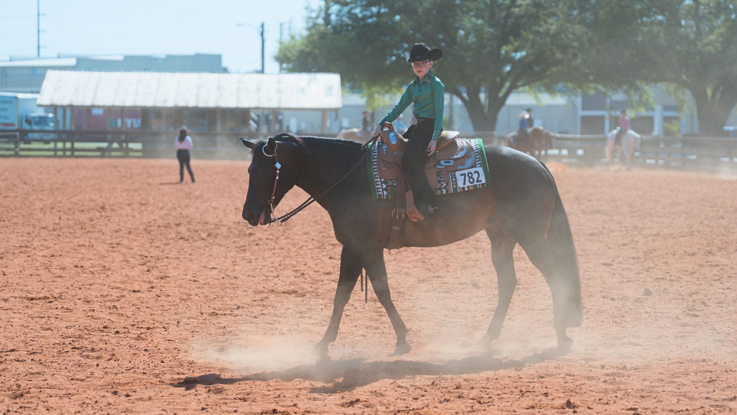 Action sequence shows a horse and rider performing a reining slide maneuver in a dusty arena.
