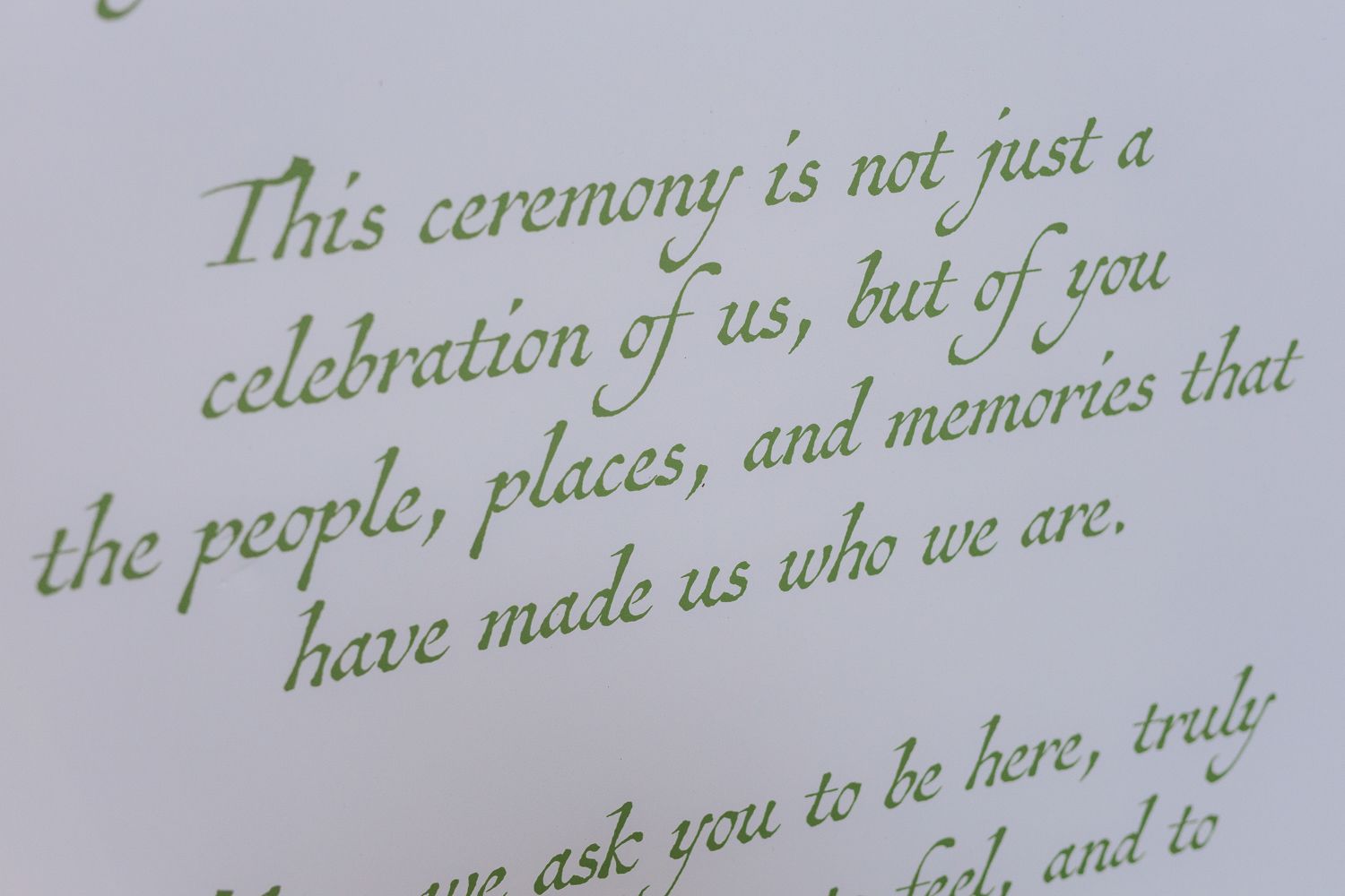 Handwritten green calligraphy text on white paper with a visible portion reading 'This ceremony is not just a'.
