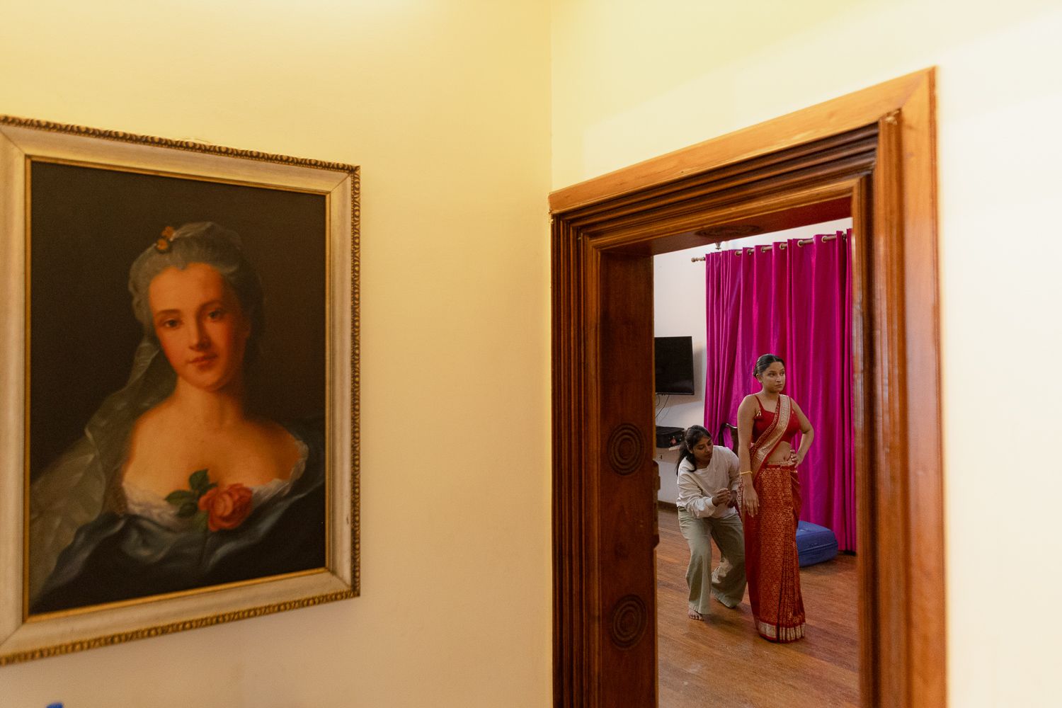 Gallery wall displaying classical portrait paintings in ornate gold frames against a cream colored wall.
