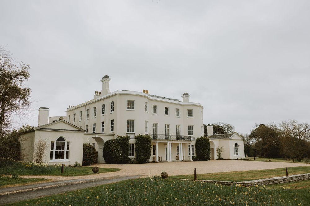 A white neoclassical mansion with columned portico photographed from multiple angles on a cloudy day.