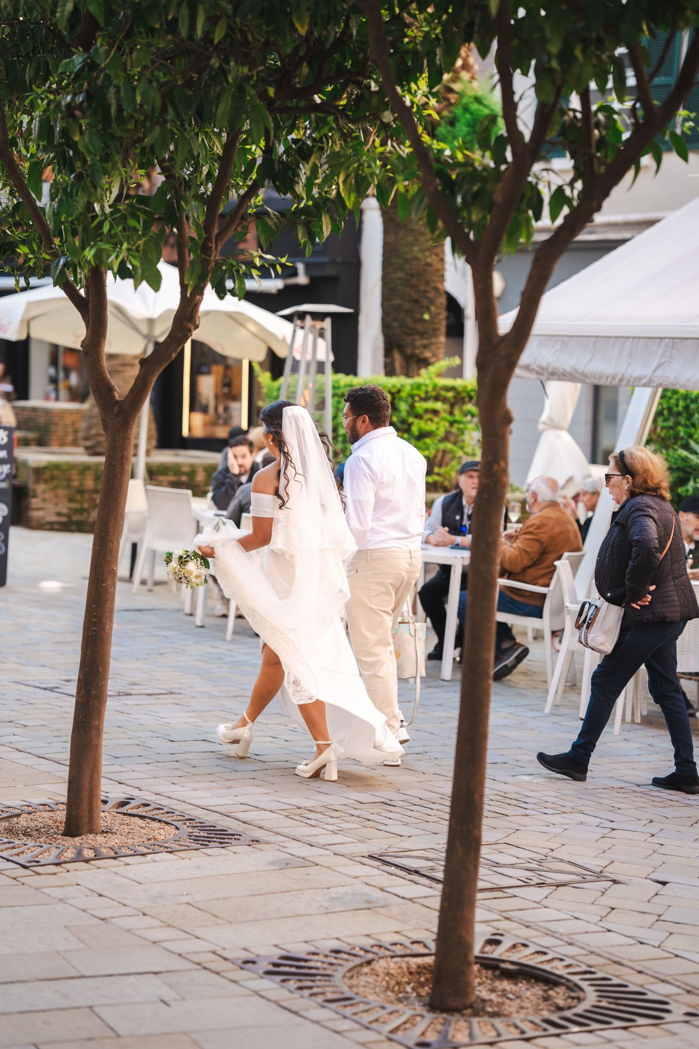 Wedding couple walking thorugh Main Street after their wedding in Gibraltar