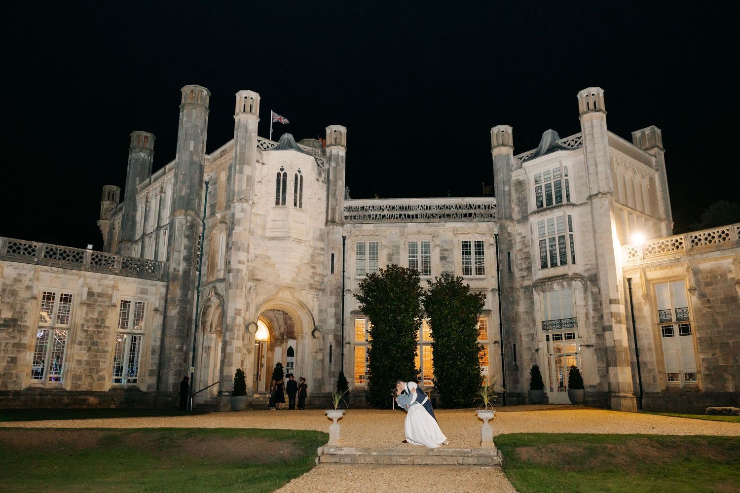Gothic stone castle illuminated at night with grand archways and architectural details creates a romantic ambiance.