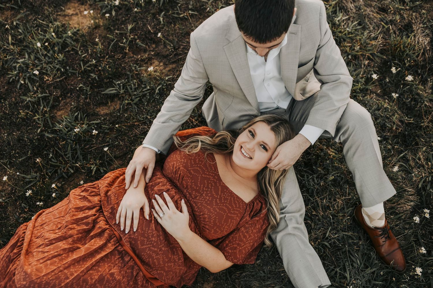 Candid engagement photos of couple laughing in a field at Murrell Park.