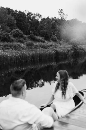 A black and white panoramic sequence shows people relaxing in white clothing by a serene lake surrounded by trees.