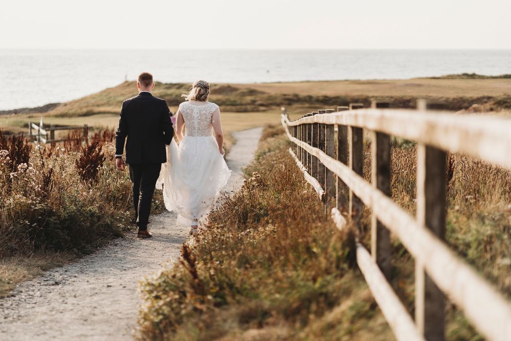 Bride and groom walking along coastal path during Ceredigion West Wales wedding photography