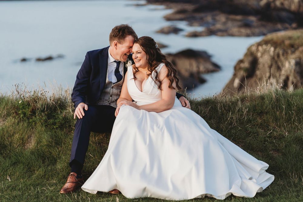 Bride and groom sat at golden hour at Ceredigion wedding venue