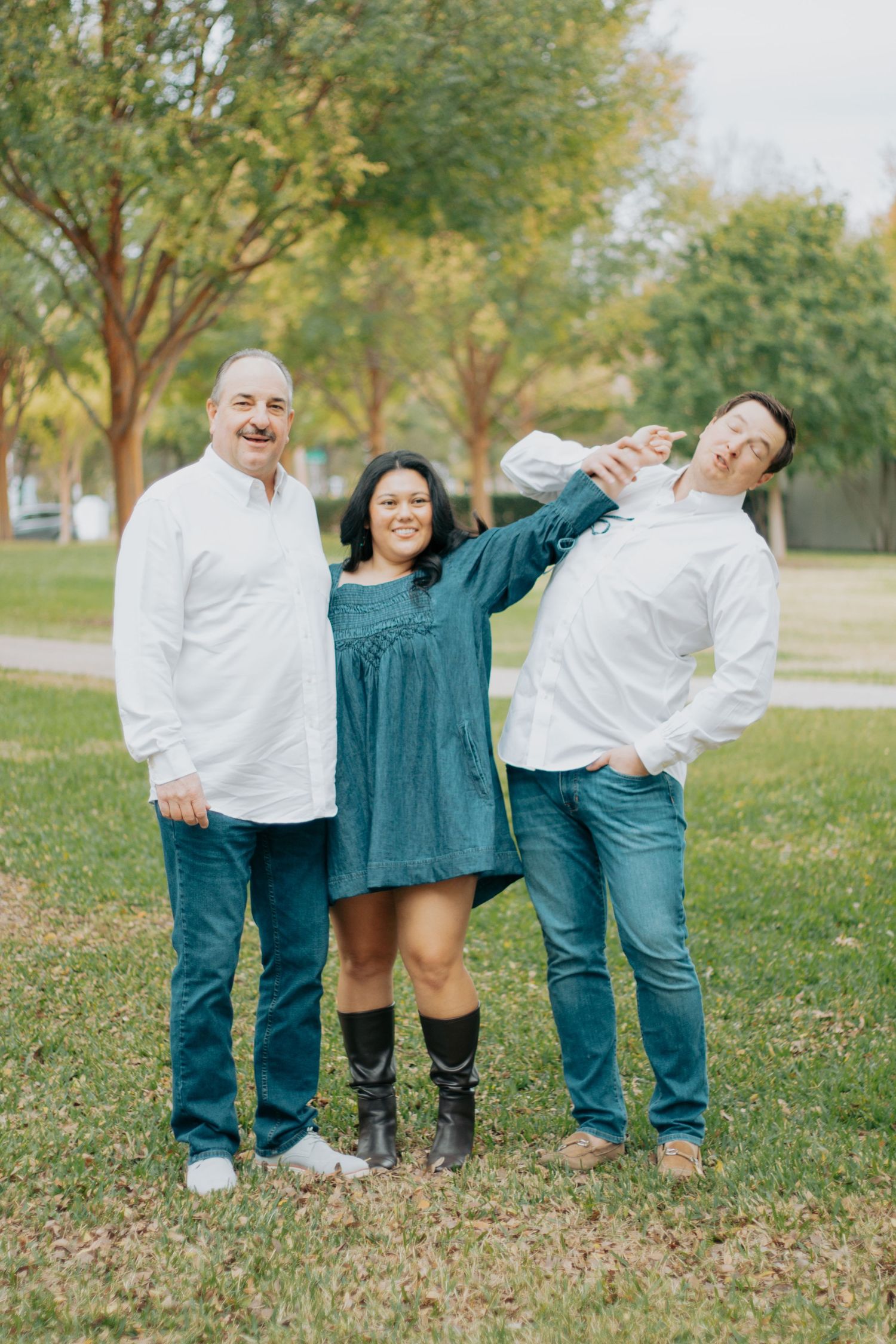 A playful outdoor family photoshoot sequence showing fun poses and laughter in a grassy park setting.