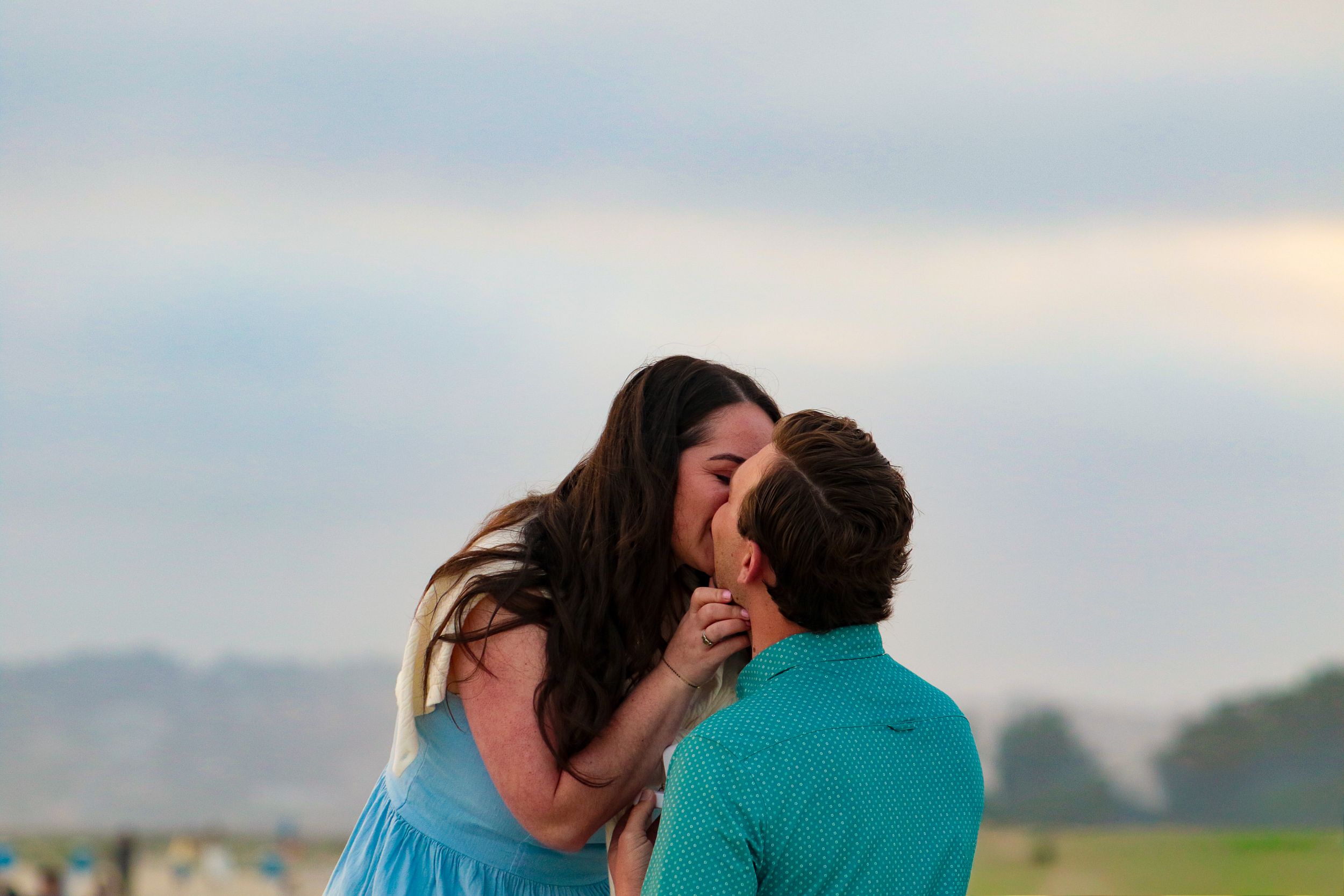 Couple sharing a romantic kiss on the beach at golden hour captured by Zeus Holbrook San Diego Wedding Photographer