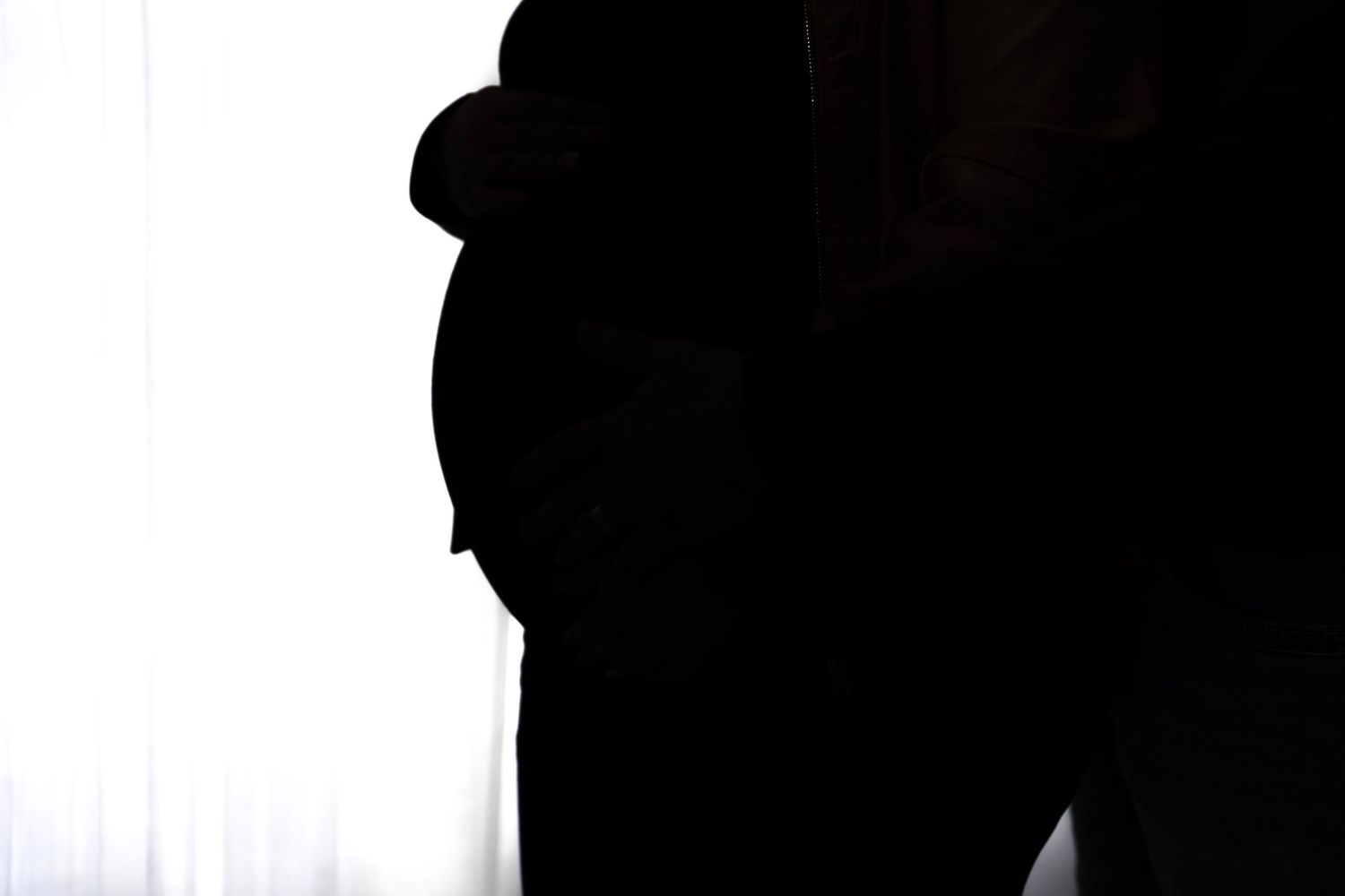 Dramatic silhouette portraits against bright window light.