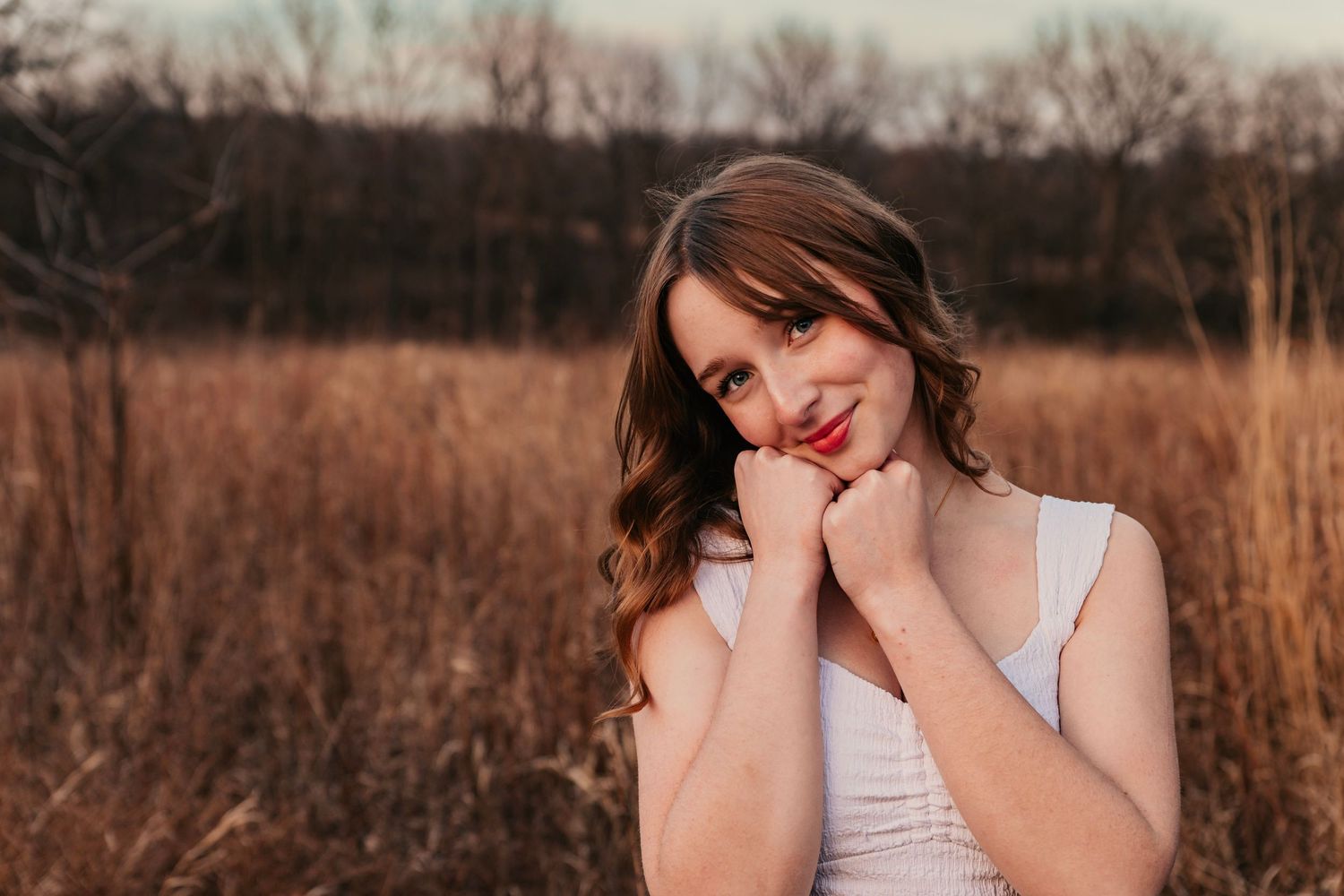 Natural light portrait session in field during sunset with soft lighting.