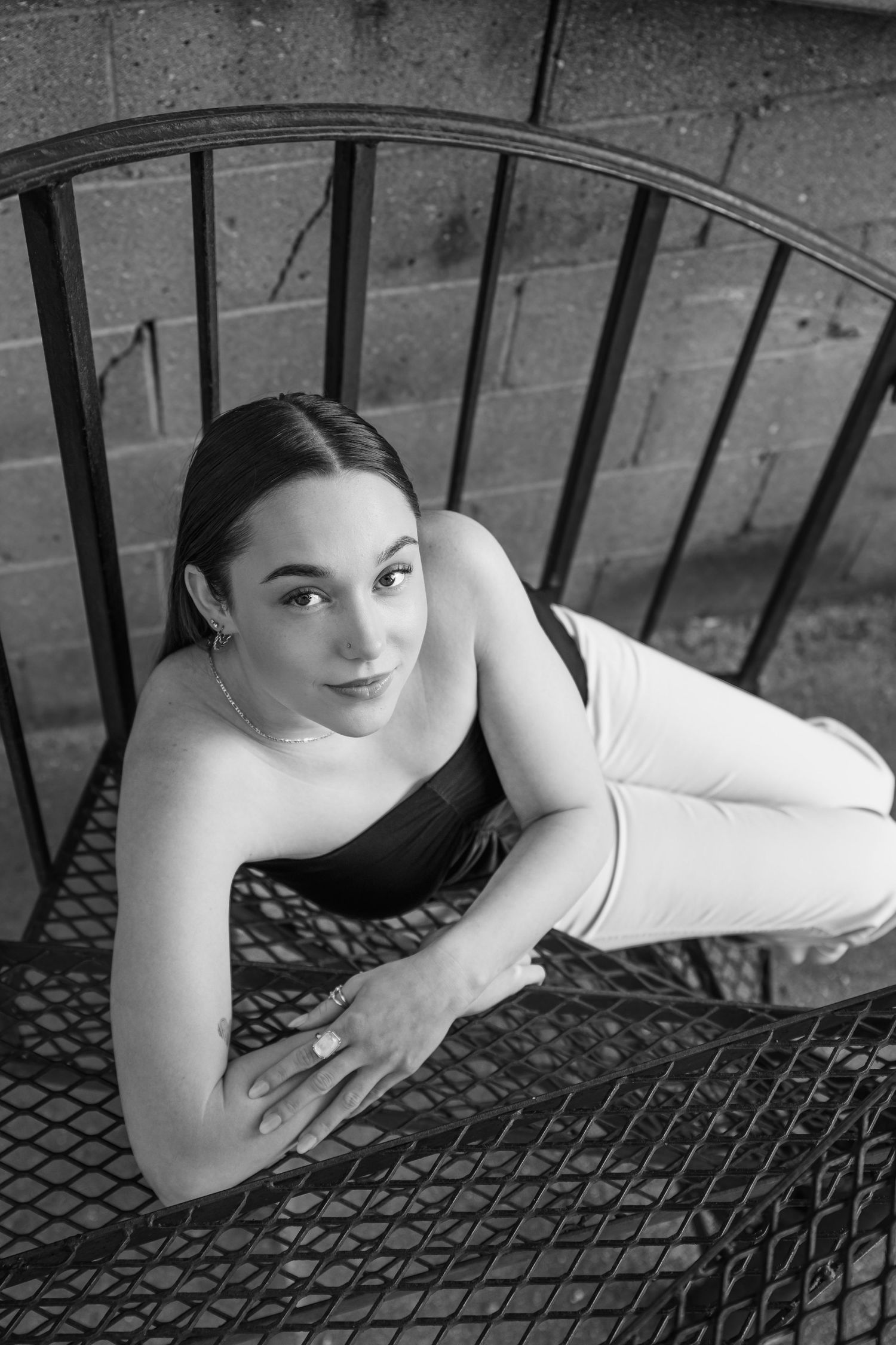 Black and white portrait series showing artistic poses on a textured metal surface.