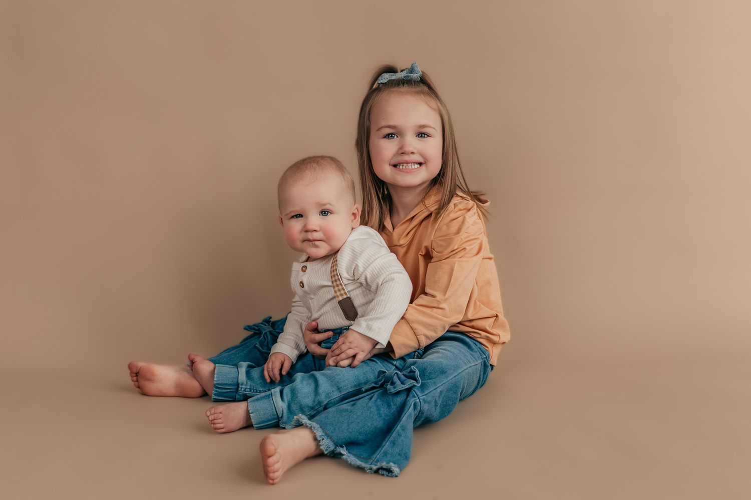 Baby milestone photos showing growth and development against neutral backdrop.