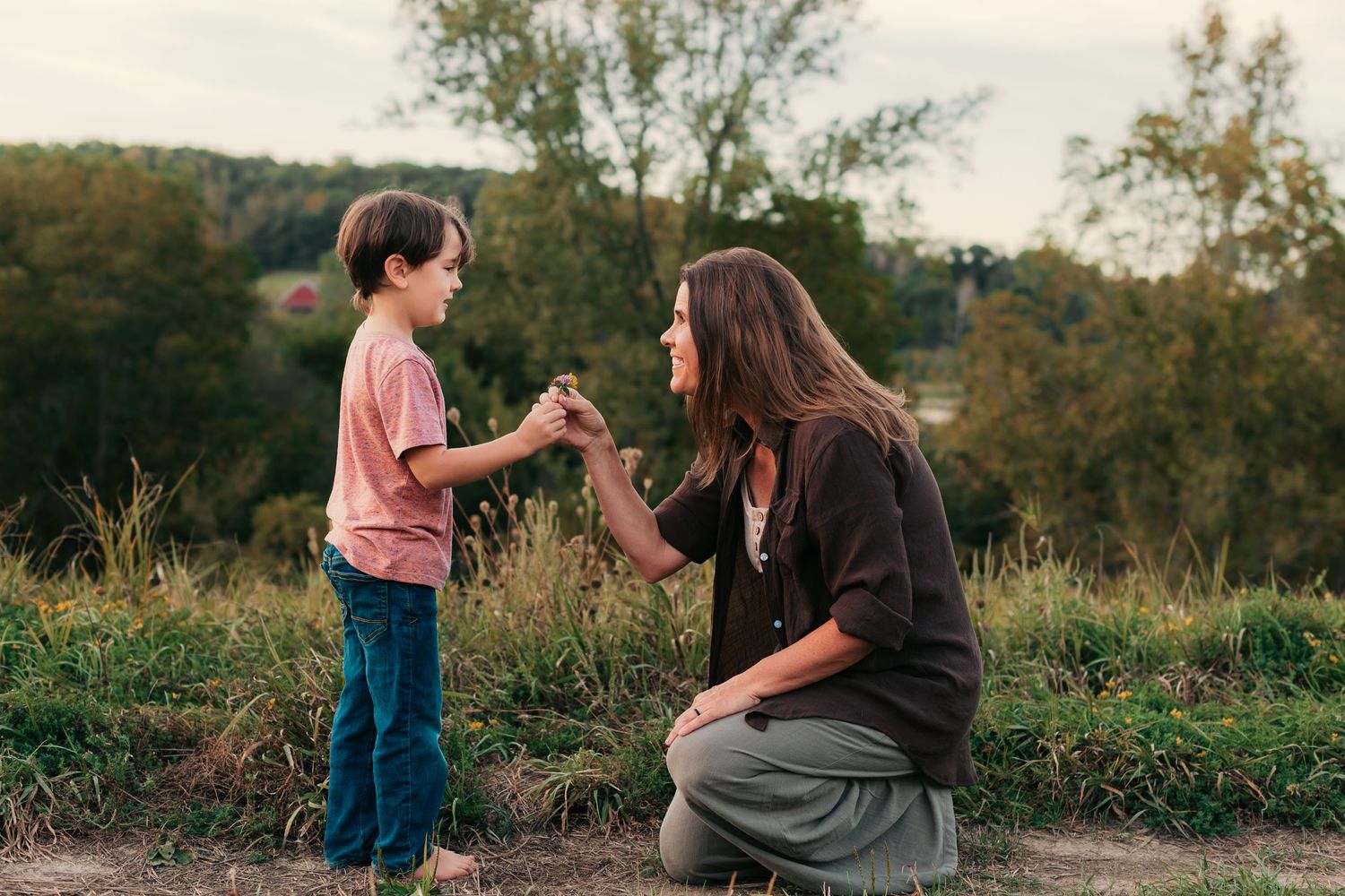 Parent and child sharing a moment together outdoors at sunset.