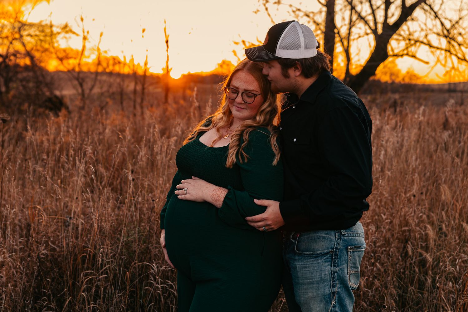 Romantic sunset engagement session in rustic field setting.