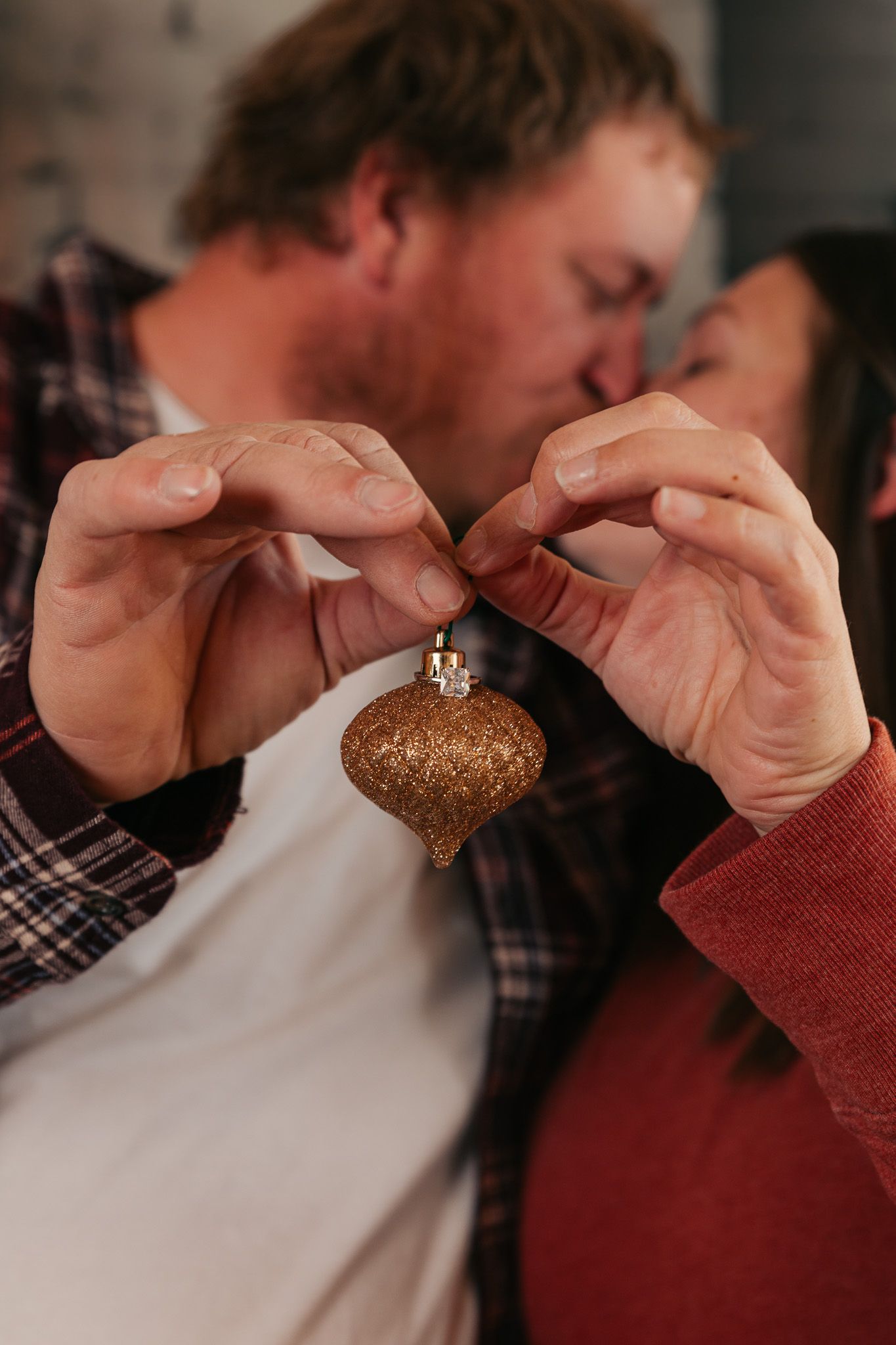 Close-up shots of hands holding a glittery ornament in dramatic lighting.
