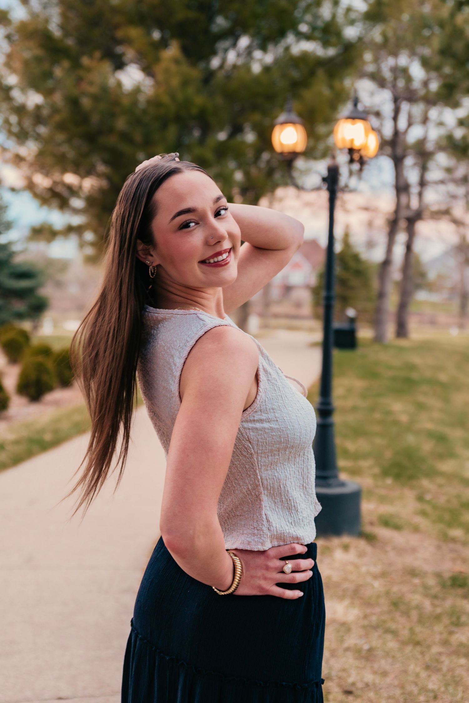 Sunset portraits along a park path with vintage-style lamp posts.