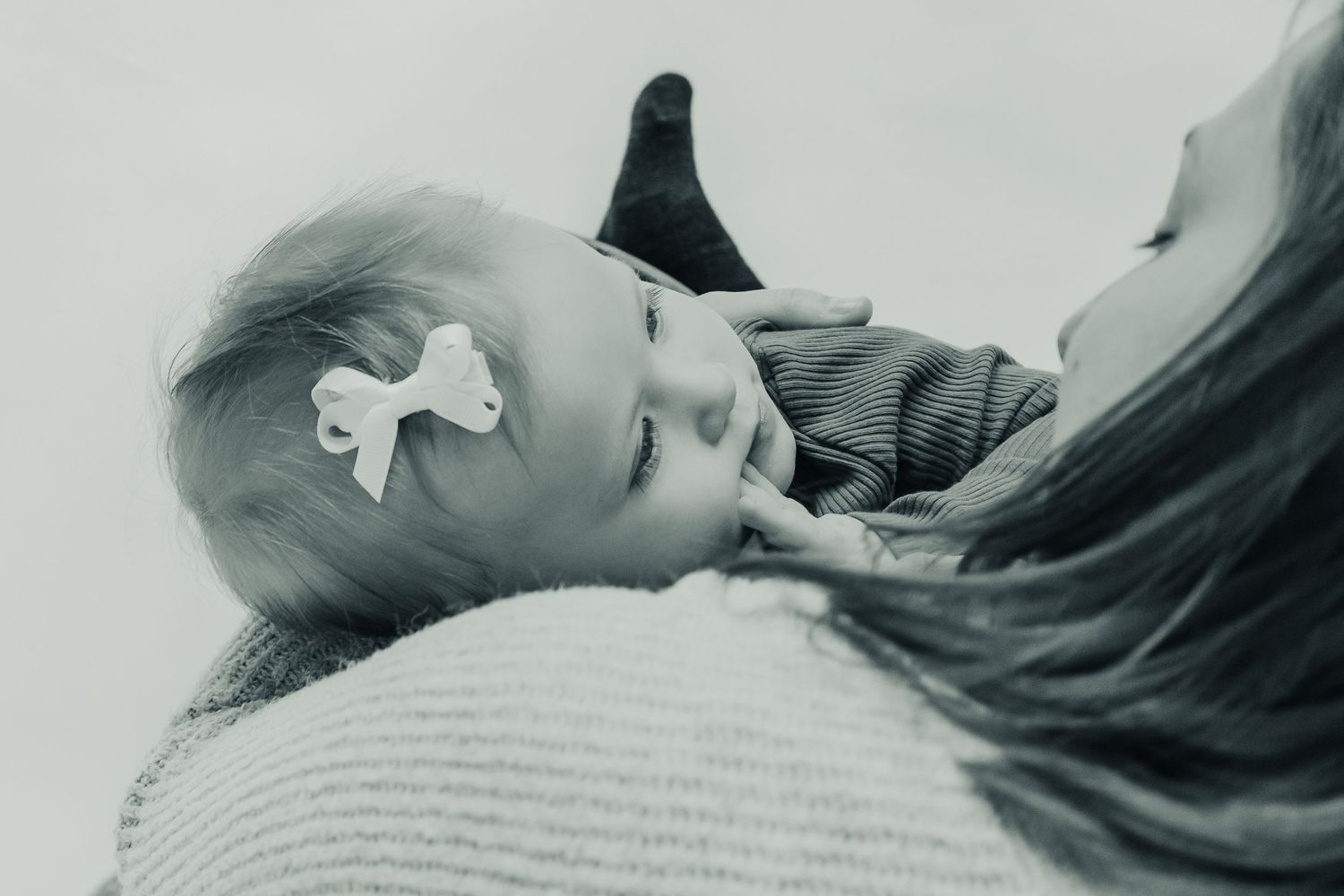 Series of black and white intimate portrait photos showing tender moments against a wooden backdrop.