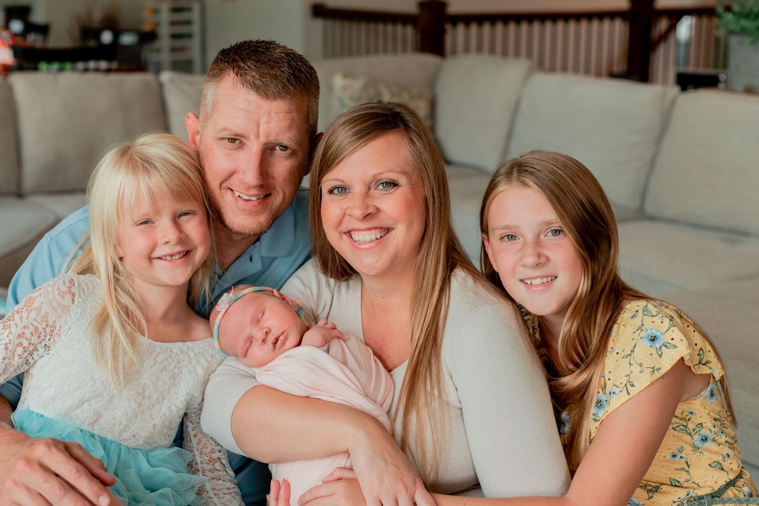 Family relaxing together on a cozy gray couch indoors.