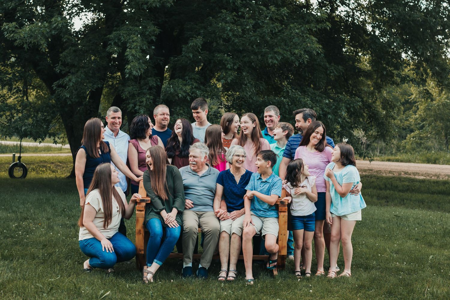 Large group sitting together outdoors on a summer day.
