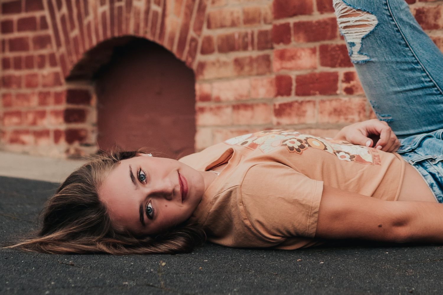 Artistic portrait series against brick wall background in warm tones.